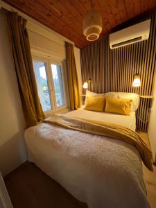a bedroom with a bed with yellow pillows and a window at Cottage by the Lake in Balatonudvari
