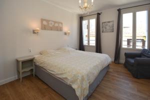 a bedroom with a bed and a couch at Maison Le Neuf Tarascon avec garage privé in Tarascon
