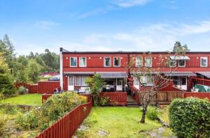a red house with a red fence and a yard at Kazan Hotel Norge in Skien