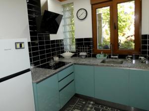 una cocina con armarios azules y un reloj en la pared en Casa Daniel, en Riberas del Sor