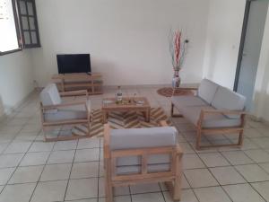 a living room with couches and a tv at Pomme Cannelle in Le Lamentin