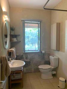 une salle de bain avec toilettes, lavabo et fenêtre dans l'établissement Mediterranean Stone Cottage, à Zikhron Yaakov 64 autres photos