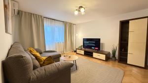 a living room with a couch and a tv at Felix 41 - Piata Victoriei, Near Metro - RH Living in Bucharest