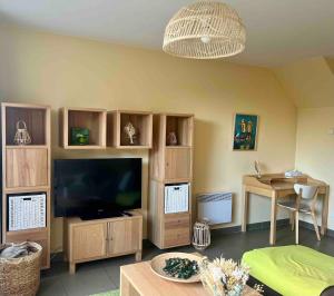 a living room with a large television and a table at L'Opaline, Ravissante maison familiale, Wimereux in Wimereux