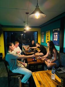 een groep mensen die rond een tafel in een café zitten bij The 10 Club Hostel in Thongsala +64 foto's