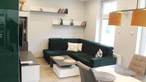 a living room with a green couch and a table at AP Apartment's Zielony in Szczawno-Zdrój