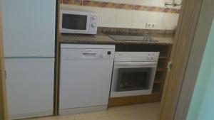 Una cocina con un refrigerador blanco y un microondas. en Marinador 1, en Oropesa del Mar