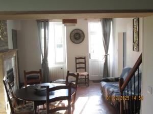 a living room with a table and a couch at maison des trois rivières in Trévières +7 photos