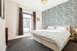a bedroom with a large bed with a floral wallpaper at The Prince's Eyrie - Spacious, comfy and cosy in Bishop Auckland