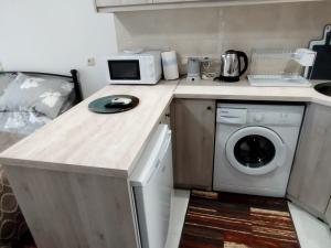 a kitchen with a washing machine and a microwave at Studio B3 in Mytilene