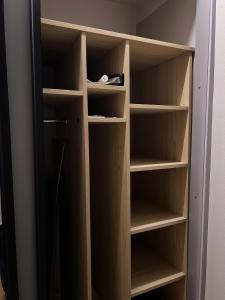 a closet with wooden shelves in a room at Mare et Ventus in Ventspils