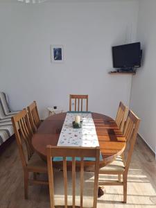 a dining room table with chairs and a television at Bernarda in Sveti Vid-Miholjice