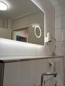 ein Badezimmer mit Spiegel und Waschbecken in der Unterkunft Appartment Messe in Köln