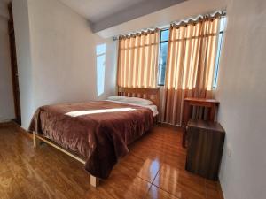 a bedroom with a bed and two windows at Sol de América in La Unión