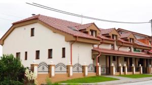 a large white building with a red roof at Penzión Altana in Ludanice