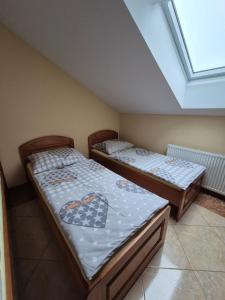 two twin beds in a room with a window at Penzión Altana in Ludanice +6 photos