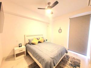 a bedroom with a bed with a ceiling fan at Amaterra 304D Seaside Luxe Condo in Cabo San Lucas +18 photos