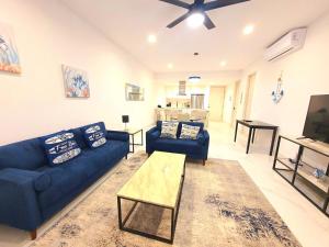 a living room with a blue couch and a table at Amaterra 304D Seaside Luxe Condo in Cabo San Lucas