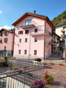 a pink building with flowers in front of it at Casa Vacanze Tel 121 in Pieve Tesino