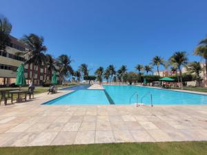 ein Swimmingpool in einem Resort mit Palmen in der Unterkunft MB06101 - Morro Branco - Térreo - 3 quartos - 2 suites in Beberibe