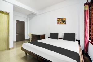 a bedroom with a large bed in a room at Super Hotel O THE HOME SPOT in Trivandrum