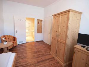 a living room with a television and a wooden cabinet at Hotel Klosterhof in St. Blasien