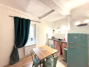 a kitchen with a table and a green refrigerator at Esprit Rétro in Tourrettes