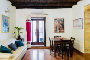 un soggiorno con un divano e un tavolo con sedie di I Carrettieri - a few steps from the Cathedral a Palermo