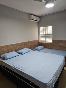 ein Schlafzimmer mit einem großen Bett mit blauen Kissen in der Unterkunft Casa Aconchegante, ideal para famílias e grupos! in Goiânia