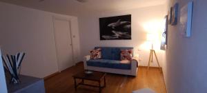 a living room with a blue couch and a lamp at Sa Domo de Paolo in Alghero