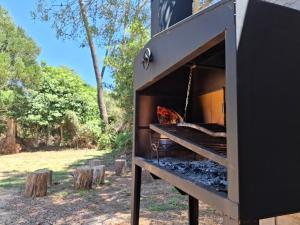 an outdoor smoker grill with logs in a field at bosque mar in Ocean Park