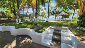 a white bench in a park with palm trees at Casita d Playa 1 in La Esmeralda