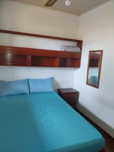 a bedroom with a blue bed and a mirror at Casa nossa hospedagem centro in Paraty +21 photos