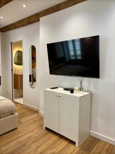 1 dormitorio blanco con TV de pantalla plana en la pared en Studio 2 Metz Centre-Ville, Gare, en Metz