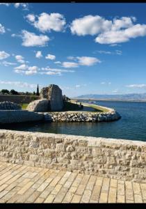 a stone wall next to a body of water at Apartment MAESTRAL Nin in Nin