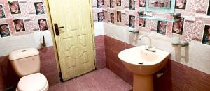 a bathroom with a toilet and a sink and a door at Hotel Palace Lodge Multan in Multan
