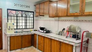 a kitchen with wooden cabinets and a counter top at Homestay Semenyih Hakim in Semenyih +5 photos