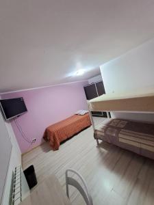 a small room with two beds and a tv at Cabaña Río Gallegos in Río Gallegos +5 photos