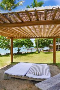 ポルト・セグロにあるCasa Nandeの木製パーゴラ(白いベッド2台付) +15枚の写真