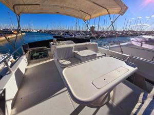 een tafel en stoelen op een boot in het water bij Moonlight Lady, our secret on the Med! in Torrevieja