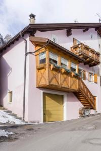a balcony on the side of a building with a yellow door at Dolomites with Love in Mazzin