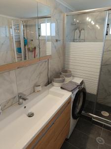 a bathroom with a sink and a washing machine at Itea's Garden House in Kírra
