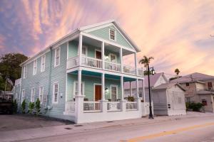 a blue house with a balcony on a street at The Lighthouse Penthouse Suite in Key West