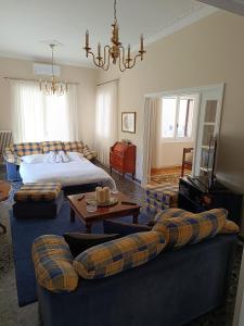 a living room with a bed and a couch and a bed and a room with at Itea's Garden House in Kírra