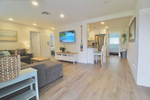 a living room with a couch and a table and a kitchen at Jensen Surf Shack in Jensen Beach