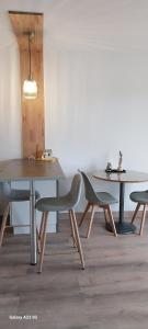 Un comedor con dos mesas y dos sillas. en joli appartement bord de mer, en Pornic