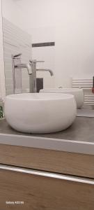 Un baño con dos lavabos y dos grifos sobre un mostrador. en joli appartement bord de mer, en Pornic