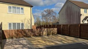 a wooden fence in front of a house at Little Luxe shared house in Bristol