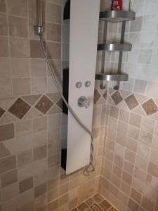 a shower with a hose in a bathroom at Maison au pied du château, terrasse in Grignan