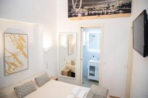 a white room with a bed and a mirror at Apartamento las setas in Seville